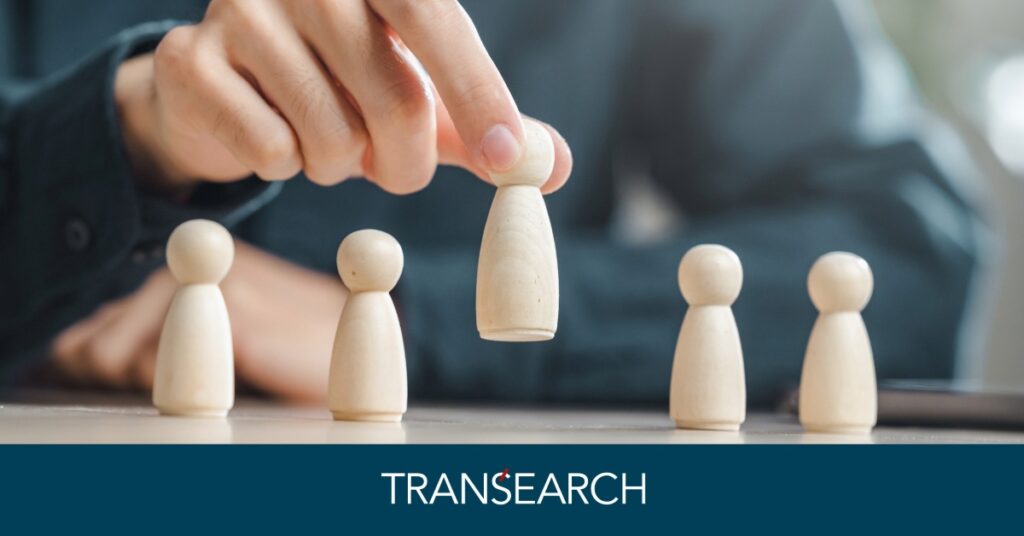 Man picking up a wooden figure in the shape of a person